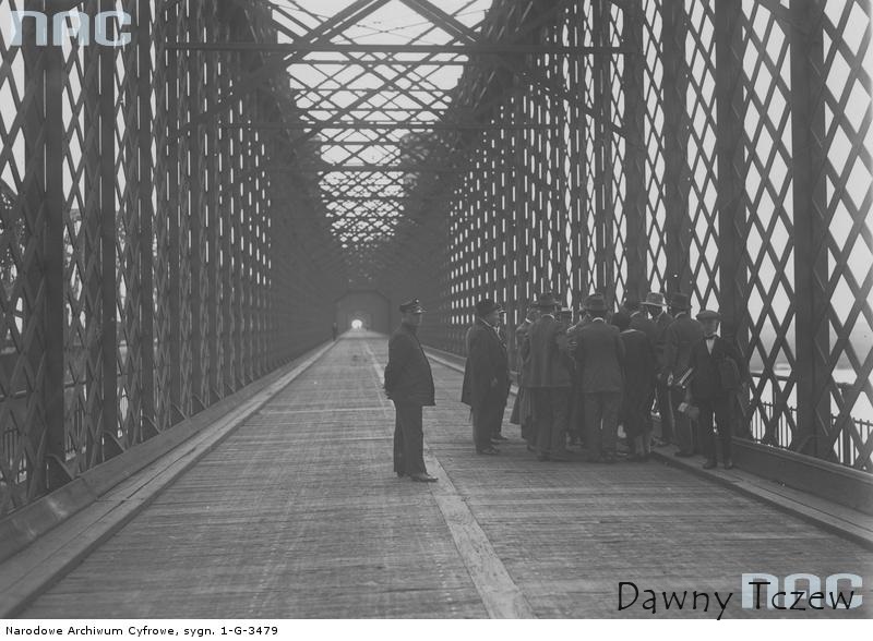 Perspektywa mostu drogowego. Widoczna grupa mężczyzn stojących na moście..jpg